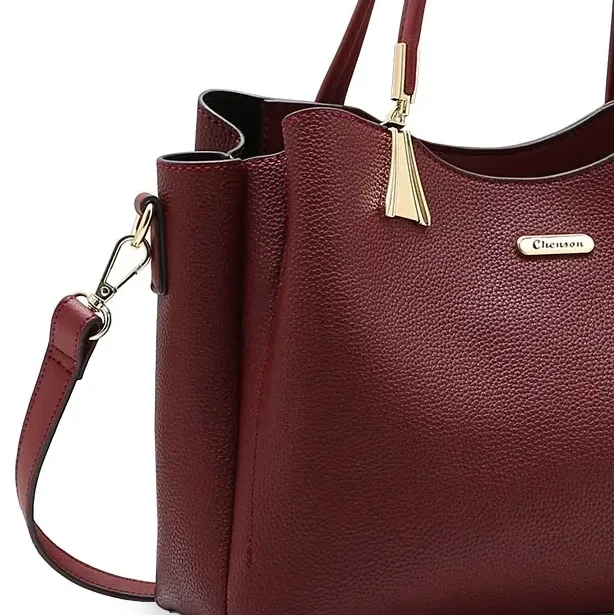 Detalhes dourados da bolsa Chenson vinho destacando acabamento premium